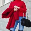 woman in red sweater beside white wall