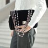 person holding black crossbody bag